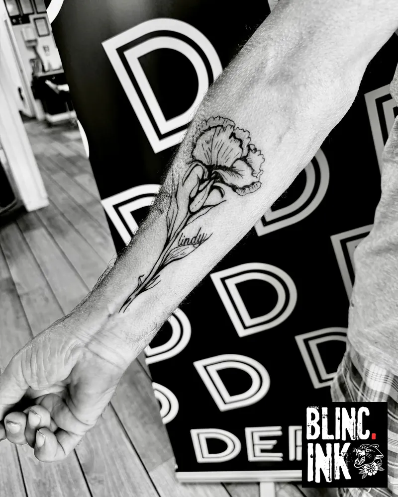 Floral Carnation: a custom woodcut-style tattoo on the forearm by Clive Camilleri at Dermoda Studio, Highbridge, Somerset.